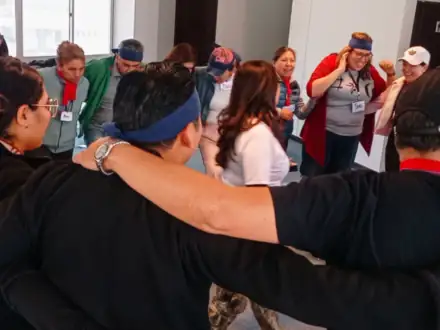 Participantes abrazados en círculo durante una dinámica de confianza.
